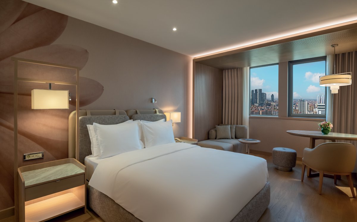 A guest room at Mövenpick Hotel Istanbul Bosphorus, with a double bed and large city-facing window